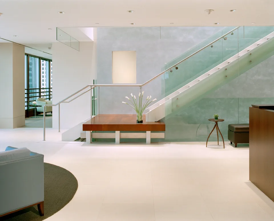 Laminated glass railing along an interior staircase and landing.