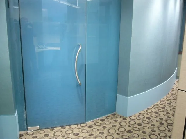 Interior laminated glass door with a metal handle.