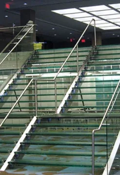 Tempered laminated glass stair treads with metal railings.
